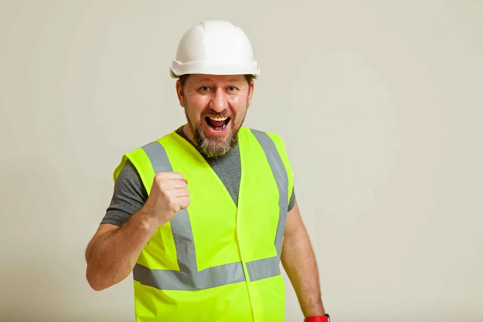 Enthousiaste bouwvakker met helm en veiligheidshesje — IT voor de bouw en afbouw