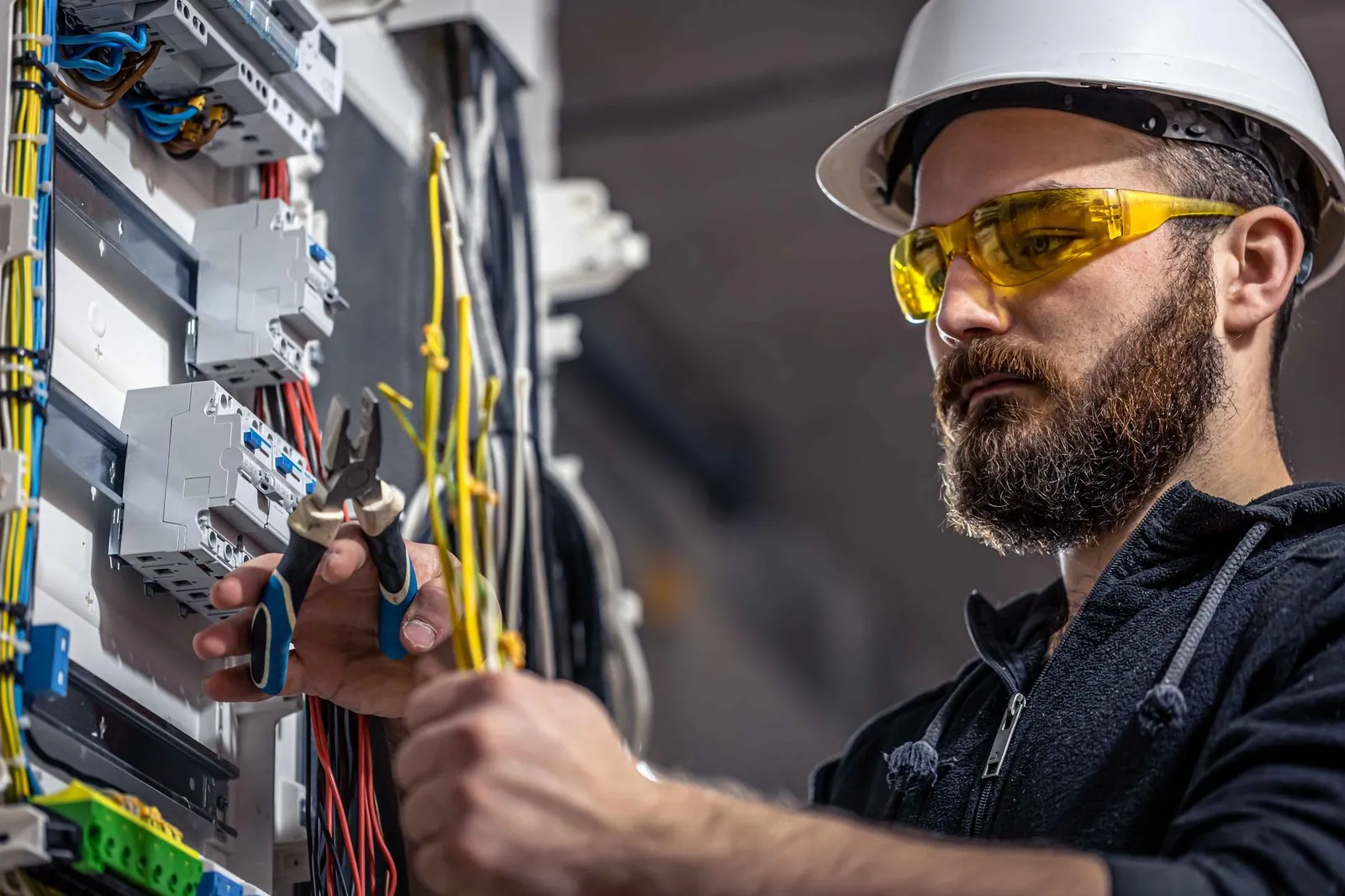 Elektricien werkt aan de bedrading van een schakelkast — netwerk en wifi die overal werken